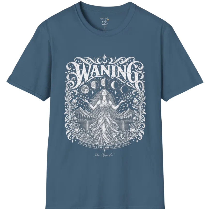 A short sleeved tee called the Waning T-Shirt, flat lay and a Gildan 64000 shirt. Simply says, Waning, Letting Go Isn't The Same As Disappearing. Design highlights a vintage-engraved crest of a robed figure with long flowing hair and open hands releasing petals beneath five moon phases, with mountains, a still lake, stars and ornate floral framing. Color is Indigo Blue.