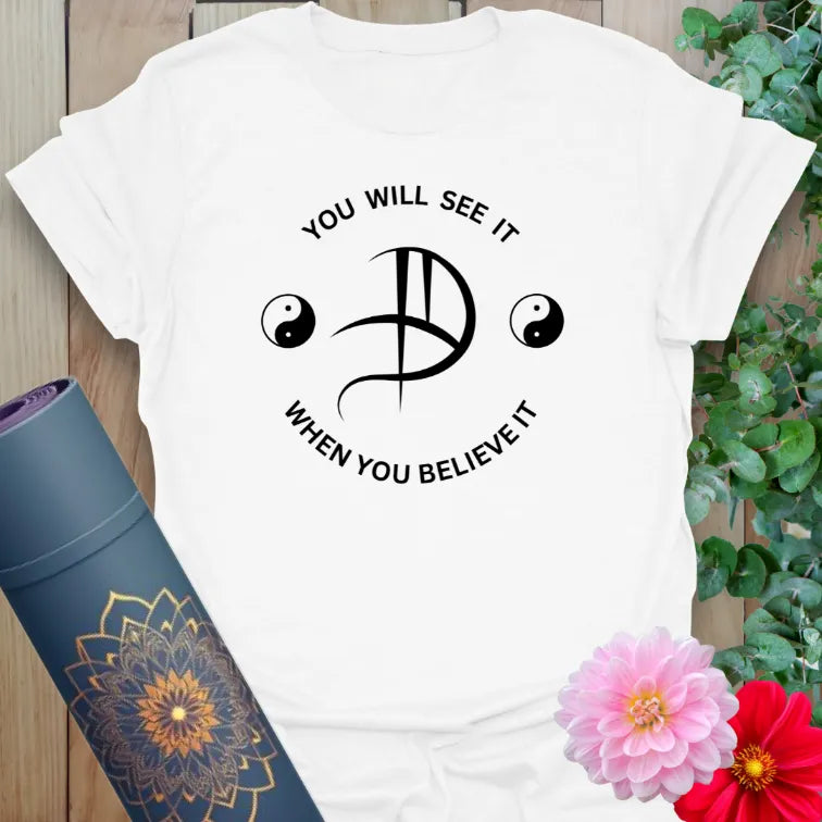 White Believe It T-Shirt with spiritual affirmation and balance symbol graphic
