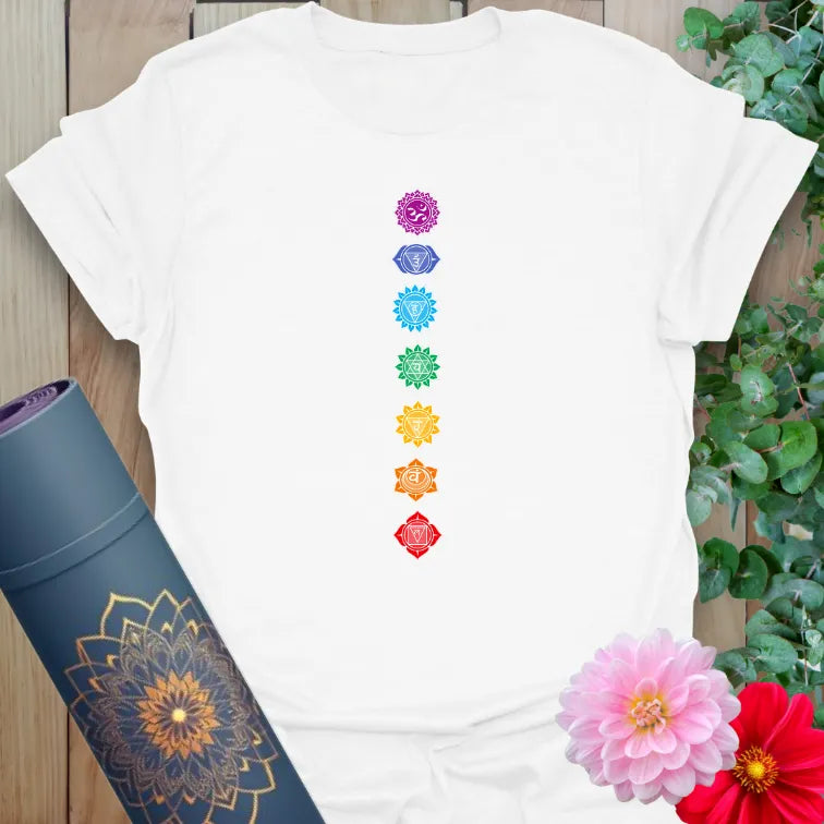Clean white unisex yoga t-shirt featuring colorful chakra alignment for conscious living and mindful practice.