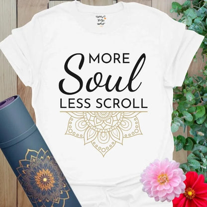 White Less Scroll T-Shirt with bold black script and golden mandala detail. Elegant and mindful statement wear.