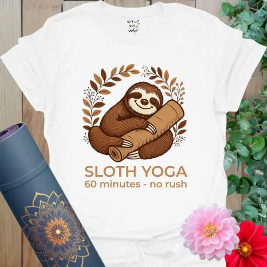 White Sloth Yoga T-Shirt featuring a relaxed sloth hugging a yoga bolster with botanical arch. Restorative yoga shirt with calm, slow-living energy.