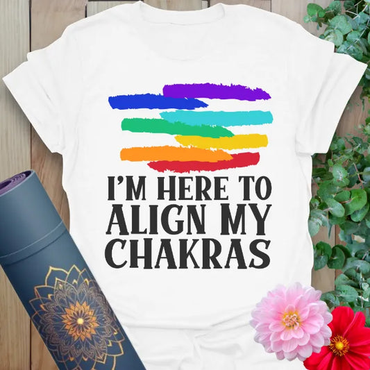 Clean white unisex yoga t-shirt with vibrant chakra color strokes and bold mindful quote for bright, high-vibe living.