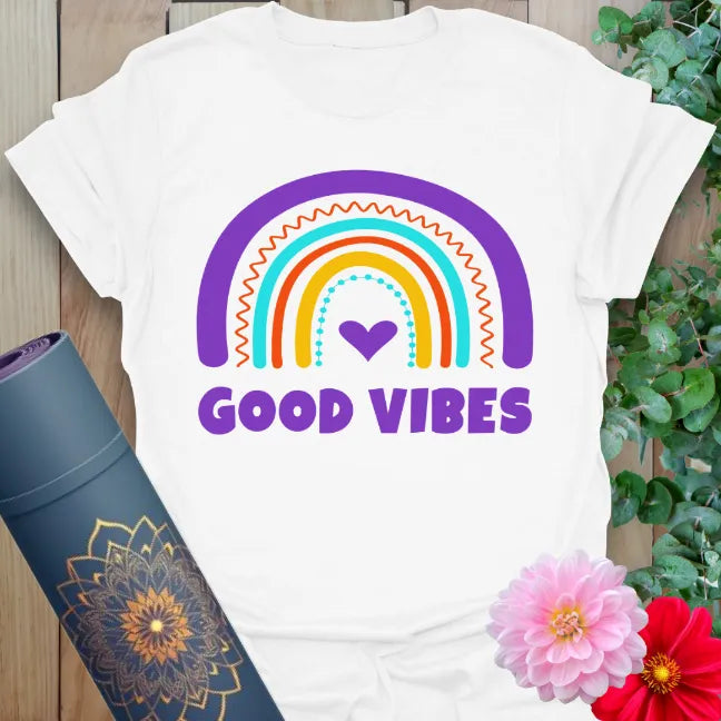 Clean white unisex tee with hand-drawn rainbow and cheerful “Good Vibes” lettering, perfect for positive living.