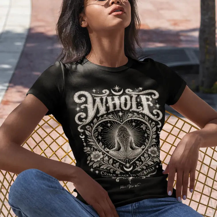 Woman wearing Whole T-Shirt seated outdoors in a woven chair, shirt in Black.