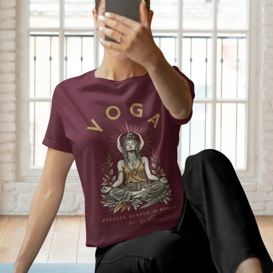 A woman takes a mirror selfie in front of large paned windows, wearing the Wrong T-Shirt. Wrong T-Shirt is a Bella+Canvas 3001 and the color is Heather Cardinal.